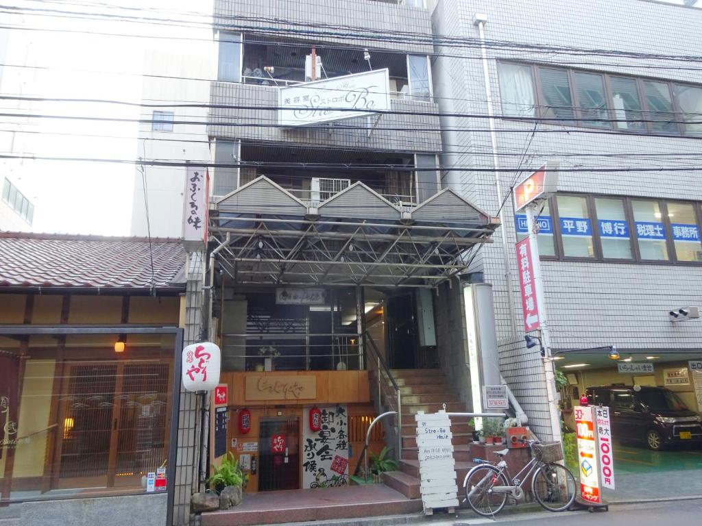 a building with a bike parked in front of it at Chidori Inn Fukuromachi Hiroshima in Hiroshima