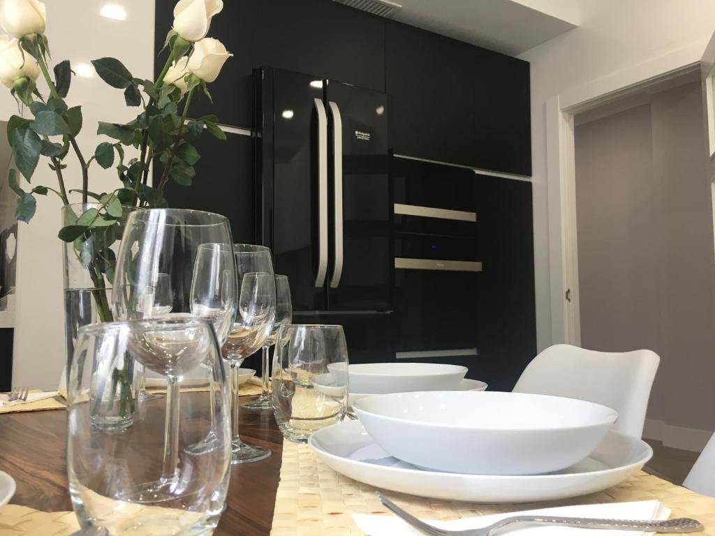 a dining room table with wine glasses and a refrigerator at Beautifulilla in Madrid