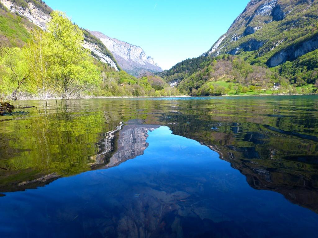 een meer in de bergen met zijn reflectie in het water bij Garnì Al Laghet in Tenno