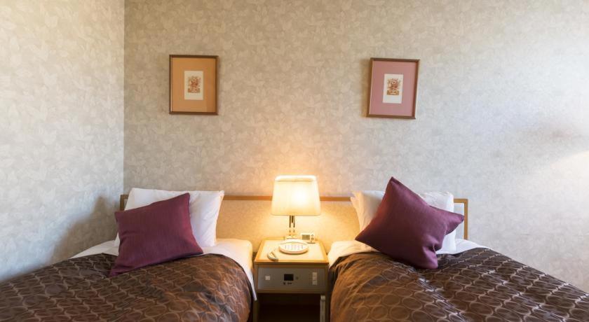 Postel nebo postele na pokoji v ubytování Sky Hotel Uozu