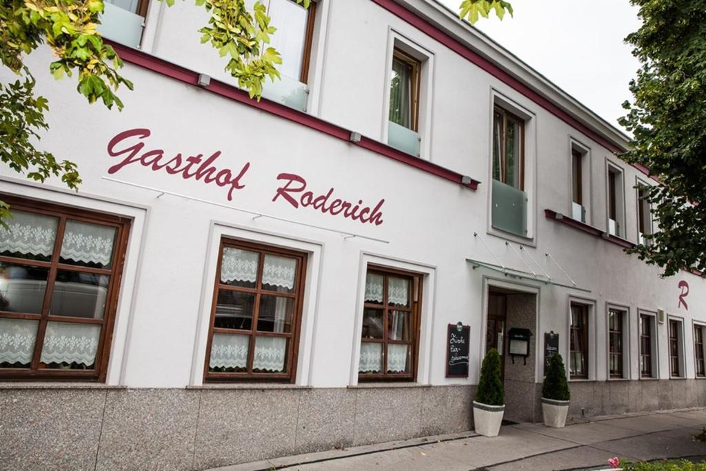 ein weißes Gebäude mit dem Namen eines Restaurants in der Unterkunft Gasthof Roderich Hotel in Langenzersdorf