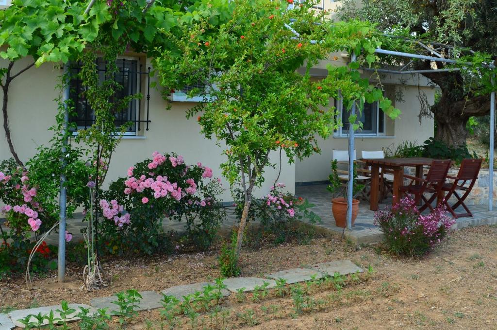 a house with a table and flowers in front of it at Villas Zoe in Skiathos
