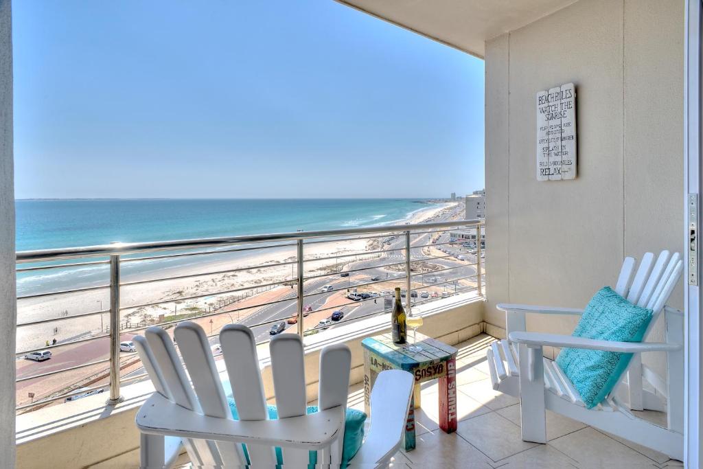 balcón con sillas y vistas a la playa en Portico 802 en Bloubergstrand