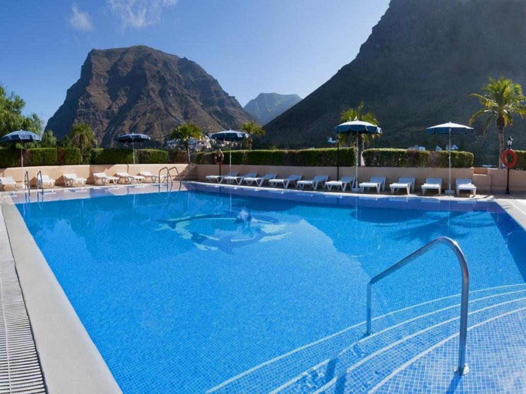 a large swimming pool with mountains in the background at Apartamentos Baja Del Secreto in Valle Gran Rey
