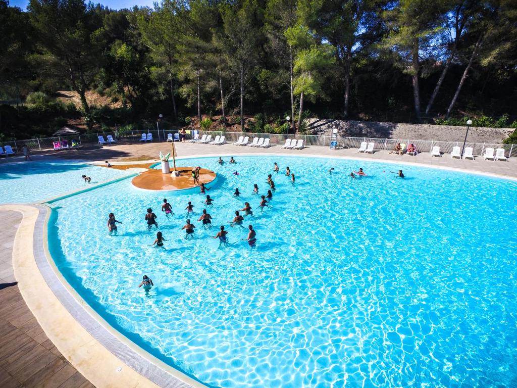 um grupo de pessoas numa grande piscina em Village Vacances Passion La Bayette em Le Pradet