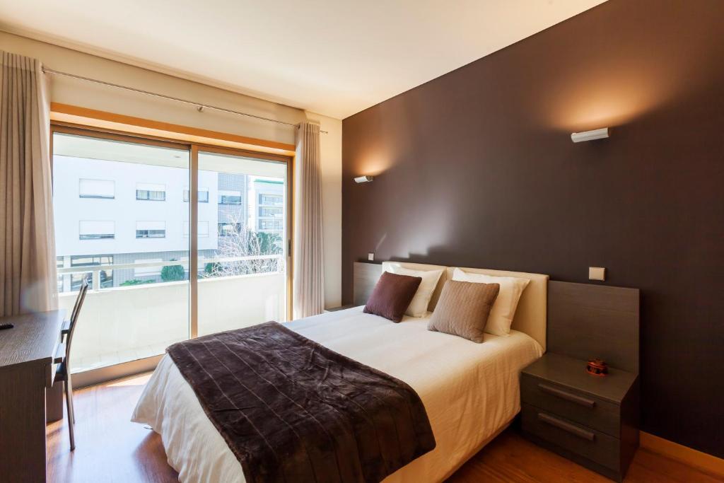 a bedroom with a large bed and a large window at Onice Apartment in Porto