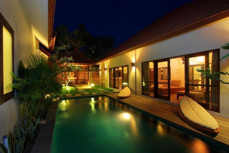 a swimming pool in front of a house at night at Ananda Private Villa in Gili Trawangan