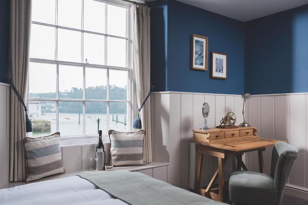 1 dormitorio con cama, escritorio y ventana en Havener's, en Fowey