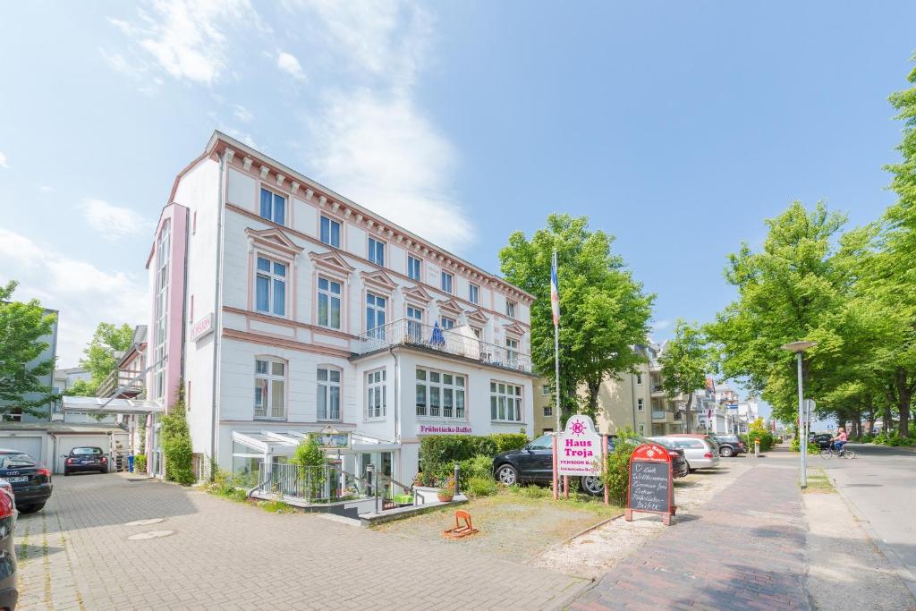 a building on a street with cars parked in front of it at Haus Troja in Warnemünde