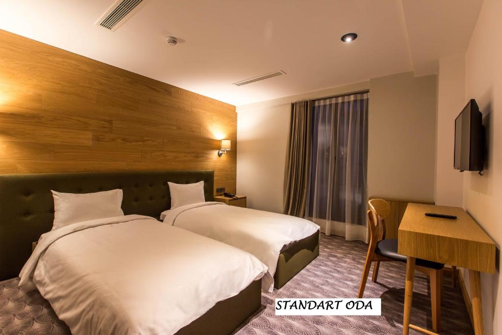 um quarto de hotel com duas camas e uma secretária em Abant Lotus Otel em Akçaalan