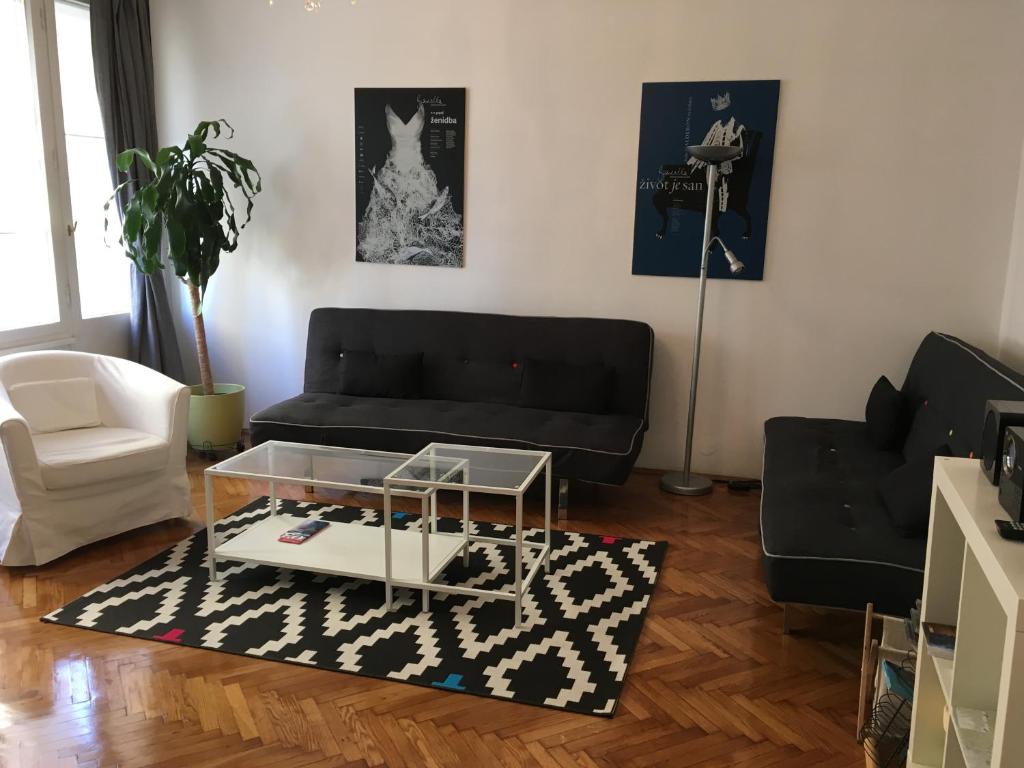 a living room with a black couch and a coffee table at Main Square Apartment in Zagreb