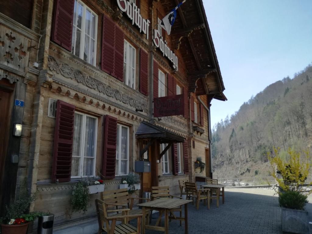 a building with tables and chairs outside of it at Gasthof Schoenegg B&B in Goldswil