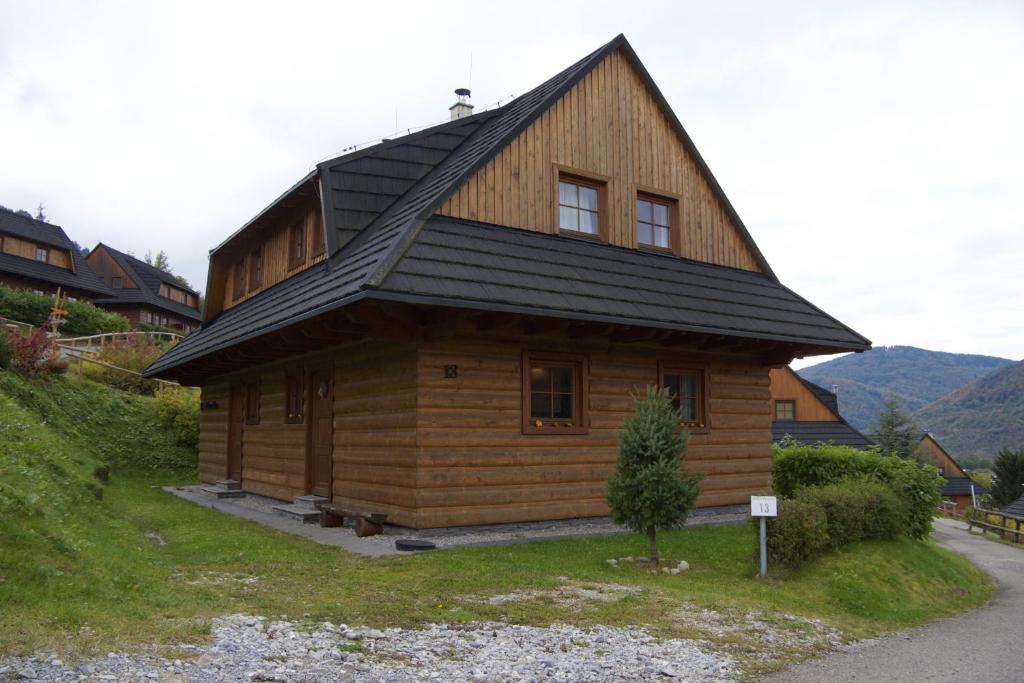 a wooden cabin with a black roof on a hill at 13 Komnata Terchová in Terchová