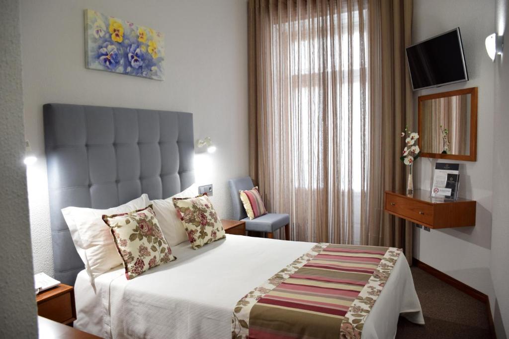 une chambre d'hôtel avec un lit et une fenêtre dans l'établissement Lusitana Hotel, à Porto