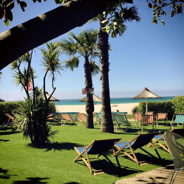 a group of chairs and umbrellas on a beach at Bungalows Tangana in Tarifa