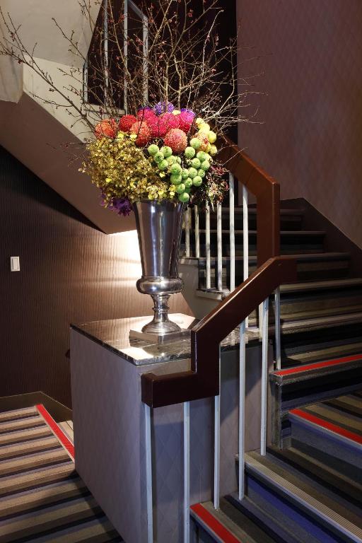a vase of flowers on a table next to a staircase at Green World Mai - NanJing in Taipei