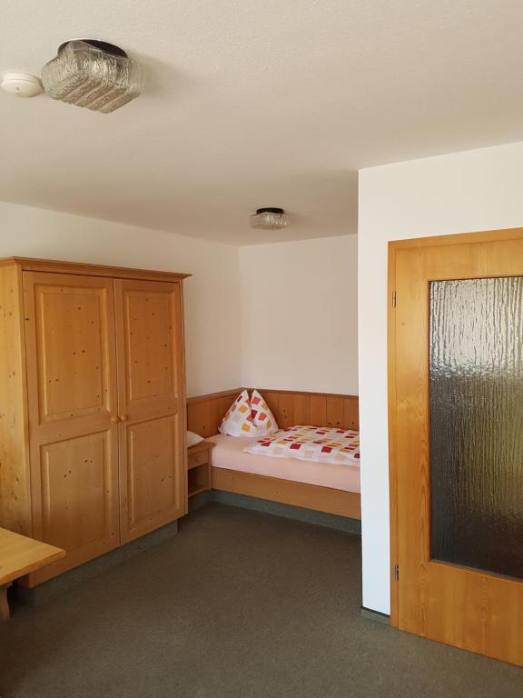 Kleines Zimmer mit einem Bett und einem Schrank in der Unterkunft Gästehaus Kübler in Weissach