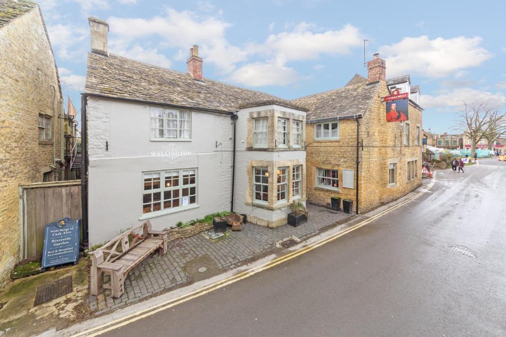 un vecchio edificio con una panchina di fronte a una strada di Duke of Wellington a Bourton on the Water