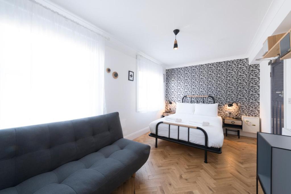a living room with a couch and a bed at The California - London Kings Cross in London