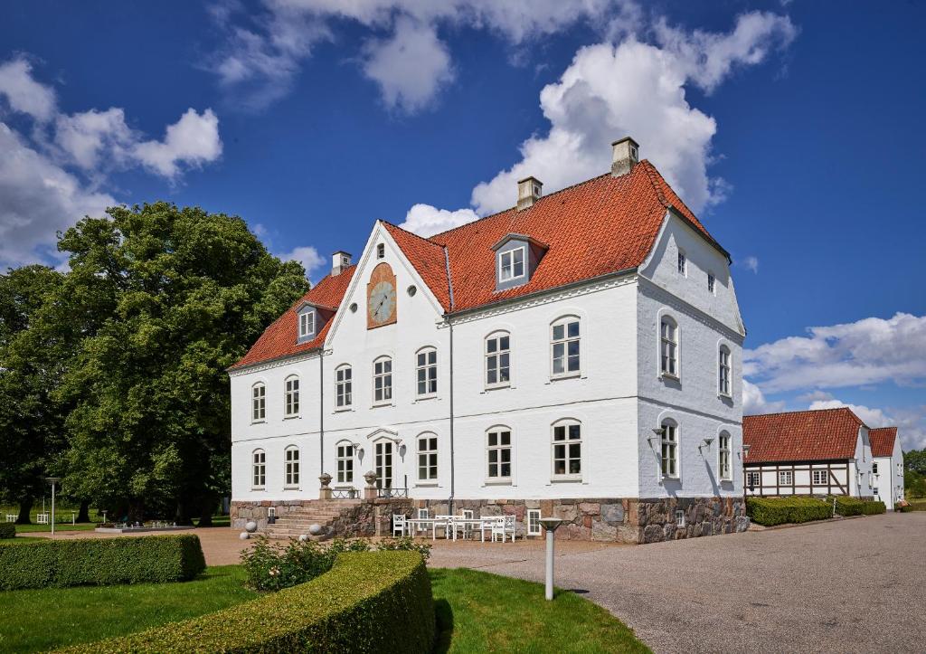 een groot wit gebouw met een rood dak bij Haraldskær Sinatur Hotel & Konference in Vejle