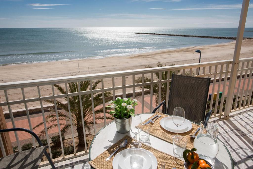 una mesa con copas de vino en un balcón con vistas a la playa en SingularStays El Faro, en Puzol