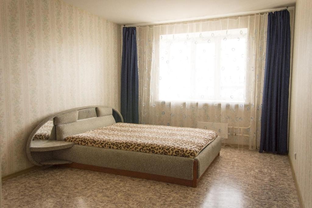 オレンブルクにあるApartment on Amurskaya 8のベッドルーム1室(窓の前にベッド1台付)