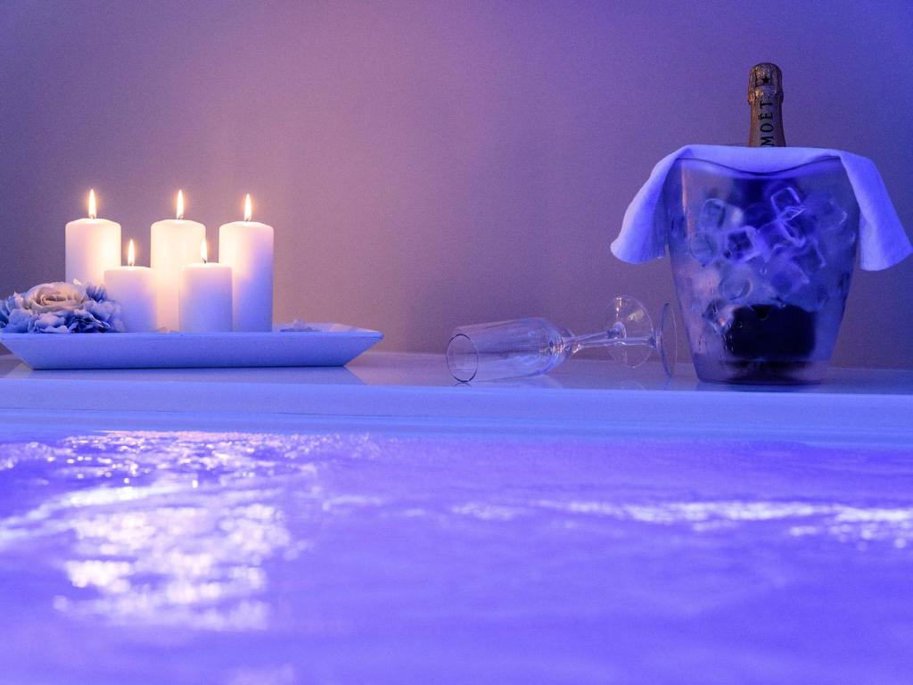 a table with candles and a bottle and a glass at Bellariva Monopoli B&B e Relax in Monopoli