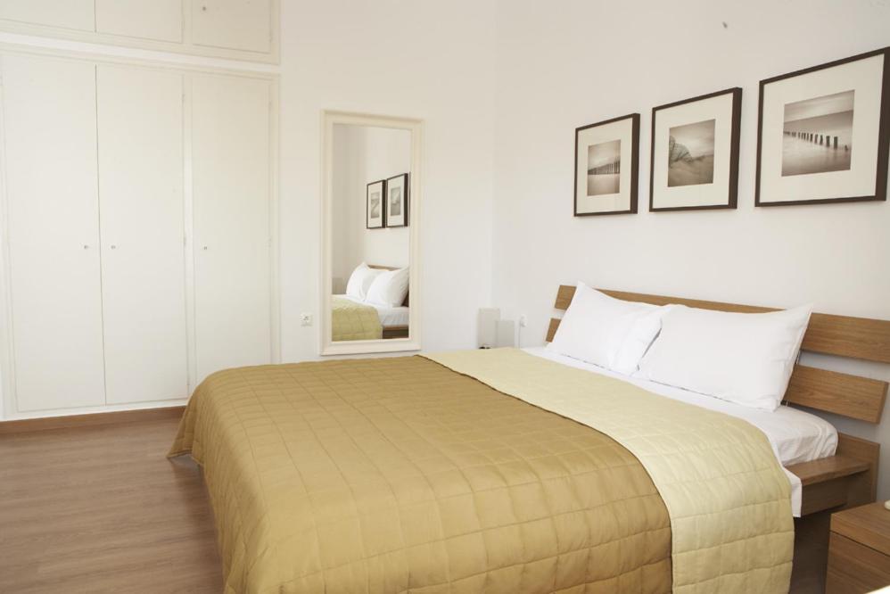 ein Schlafzimmer mit einem großen Bett mit weißen Wänden in der Unterkunft Casa Aiora in Adamas