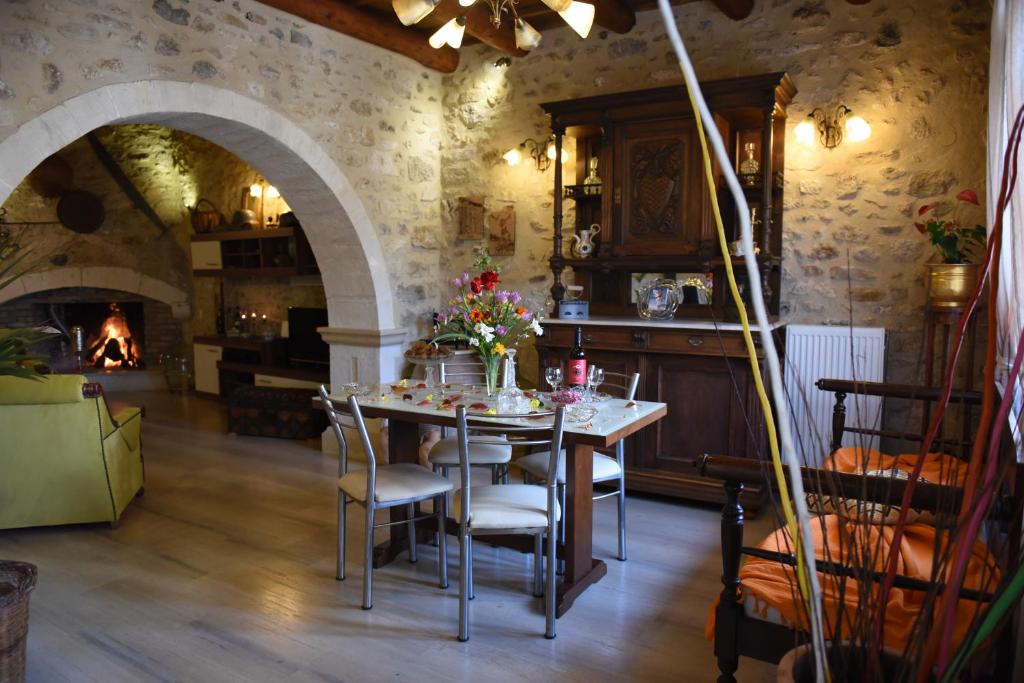 a dining room with a table and chairs and a fireplace at Crete Villa Estia in Arménoi