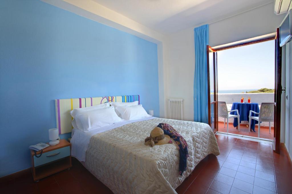 a bedroom with a bed with a teddy bear on it at Iris Hotel in Ischia