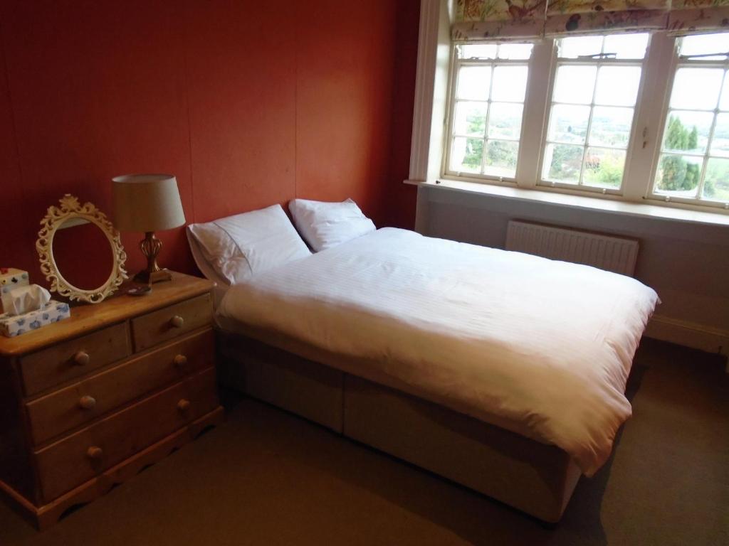 a bedroom with a bed and a dresser and a window at Ballynona House in Midleton