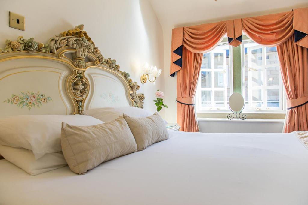 - une chambre avec un grand lit blanc et une fenêtre dans l'établissement Santo's Higham Farm Hotel, à Alfreton