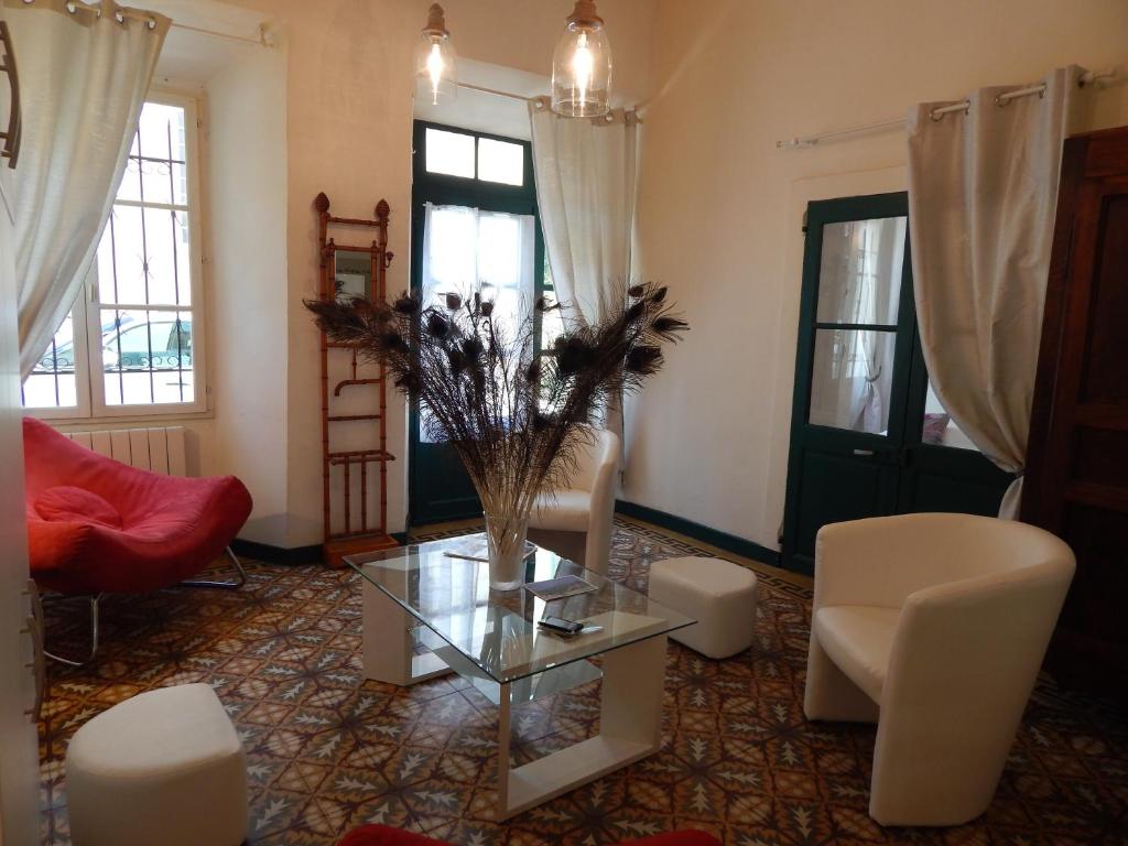 ヴェゾン・ラ・ロメーヌにあるla clef du couventのリビングルーム(ガラスのテーブル、椅子付)
