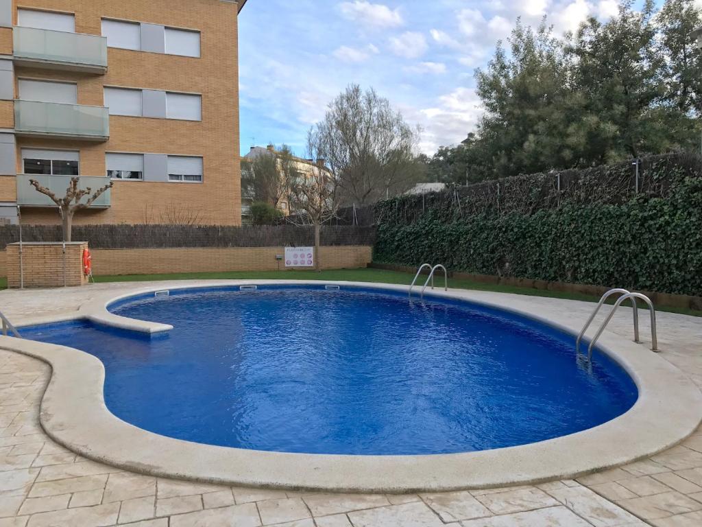 a swimming pool in front of a building at Lets Holidays Cozy Pool Apartment in Tossa de Mar