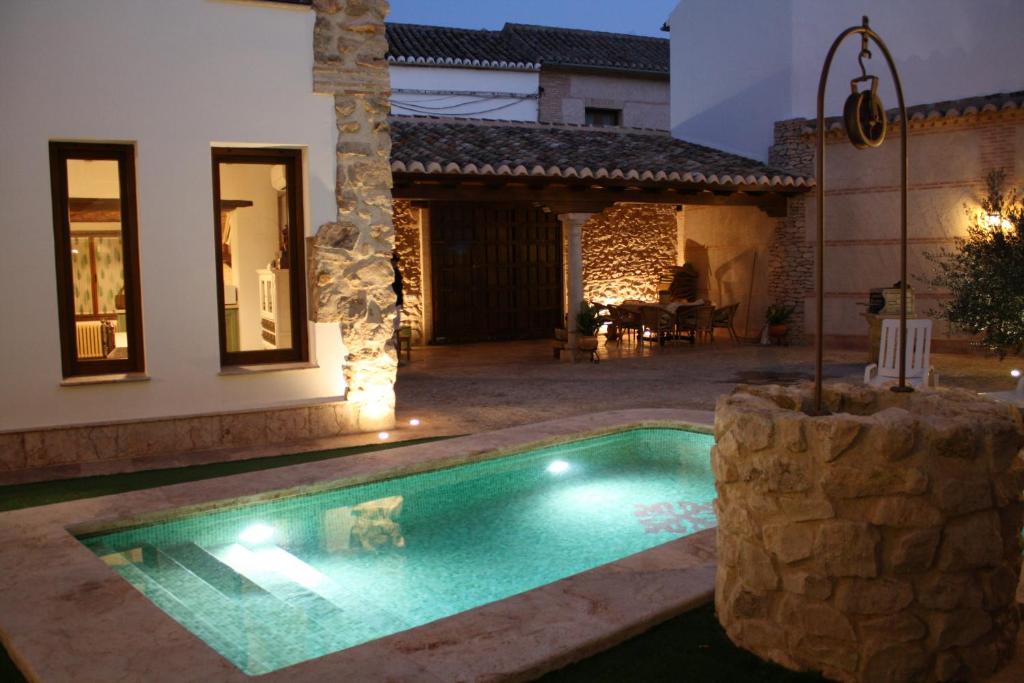 a swimming pool in front of a house at night at Loft Yedra in Almagro