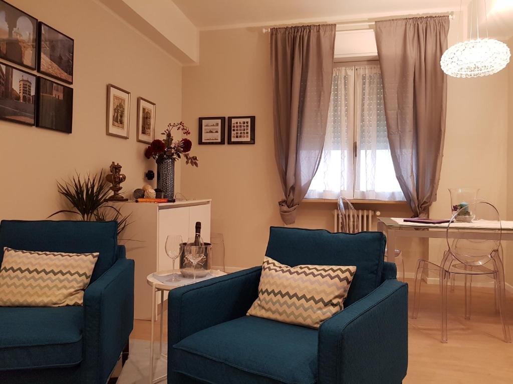 ein Wohnzimmer mit 2 blauen Stühlen und einem Tisch in der Unterkunft Parma City Centre Holiday House in Parma