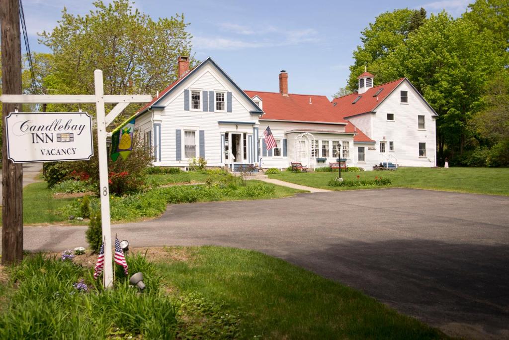 ein Kreuz vor einem weißen Haus mit einem Schild in der Unterkunft Candlebay Inn in Freeport