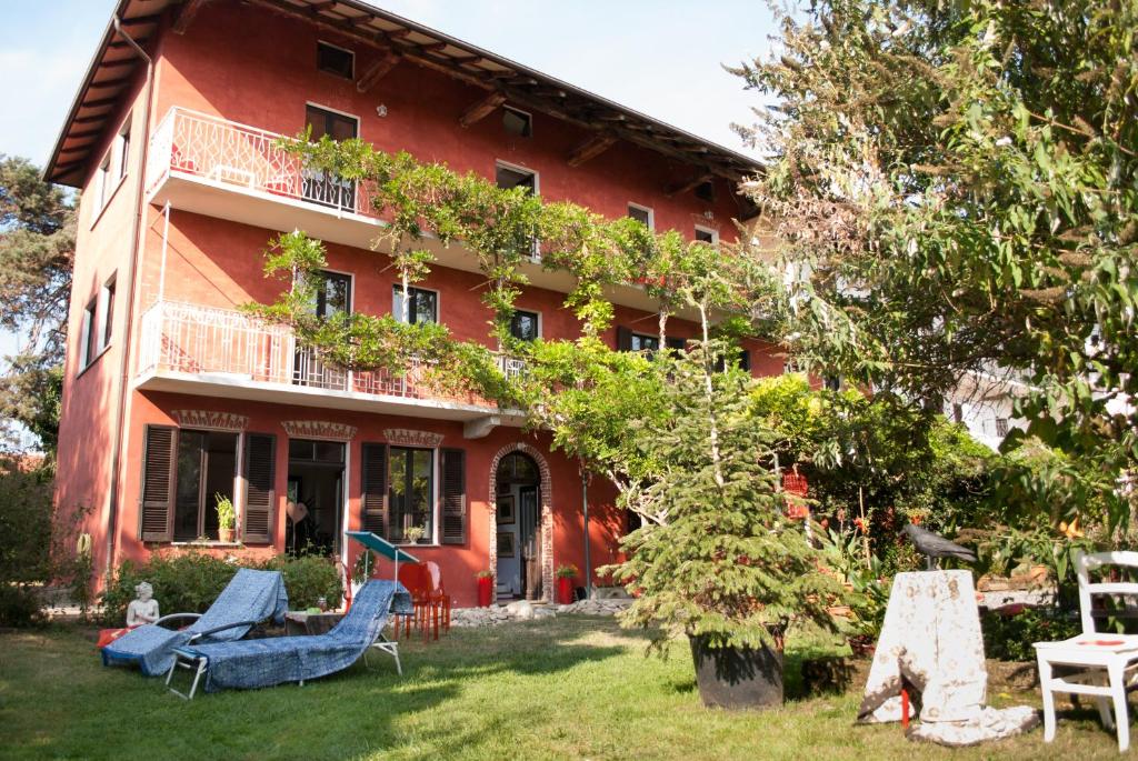 ein rotes Haus mit blauen Möbeln im Hof in der Unterkunft Otium B&B in Cavallirio