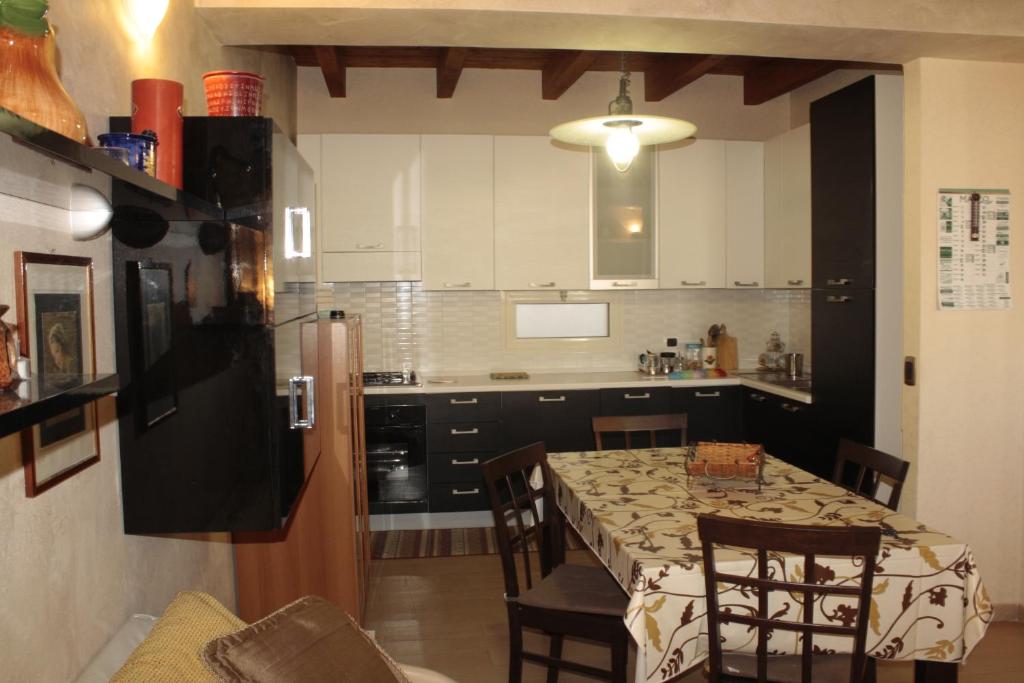 Il comprend une cuisine équipée d'une table, de chaises et d'un réfrigérateur. dans l'établissement Casa-B&B Bouganville Attico 85 mq, à Barletta