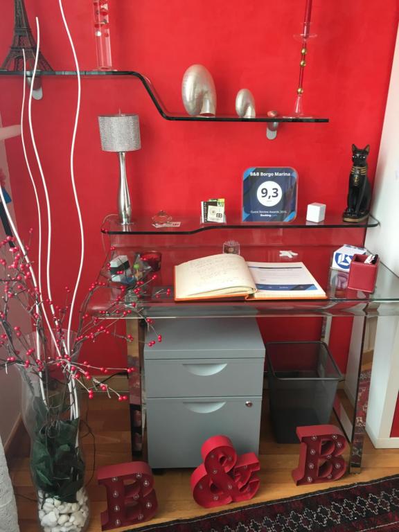 un ufficio con una parete rossa e una scrivania di B&B Borgo Marina a Bordighera