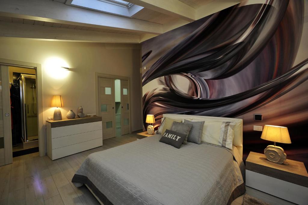 サンタントーニオ・アバーテにあるLuxury Apartment Della Marcaのベッドルーム1室(壁に絵画が描かれたベッド1台付)