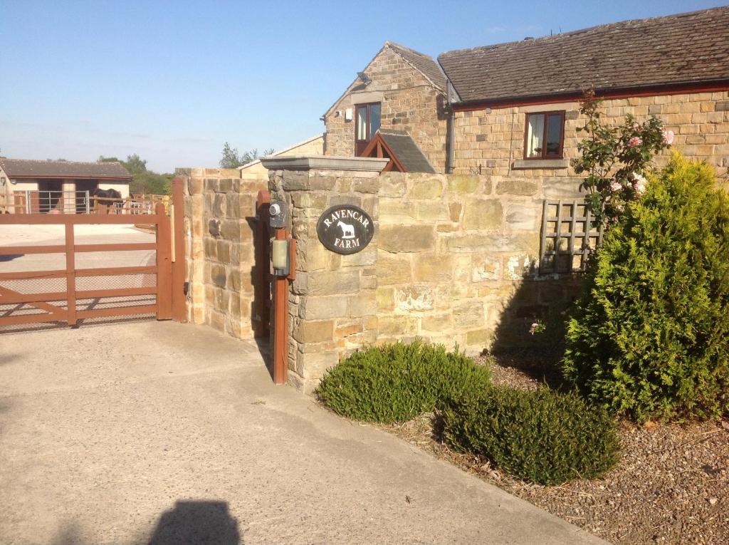 ein Backsteingebäude mit einer Uhr auf der Seite in der Unterkunft Ravencar Farm B&B in Eckington