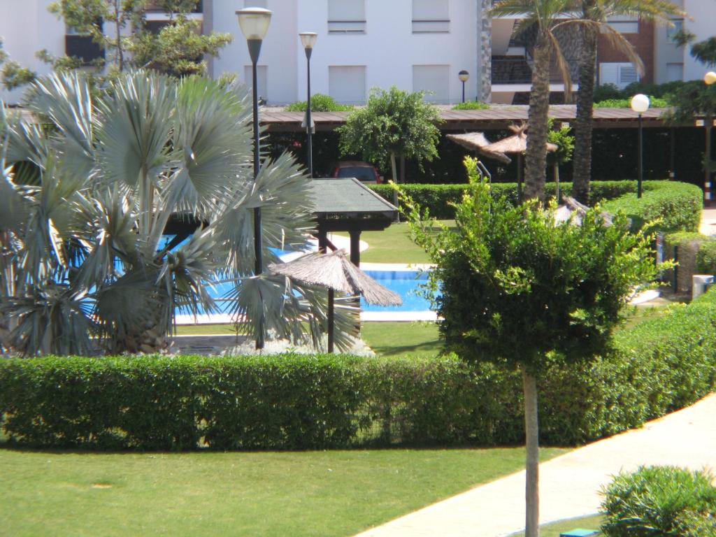 un complejo con piscina y palmeras en Apartamento VenAVera Playa Jardines de Nuevo Vera M1-1B Primera Línea, en Vera