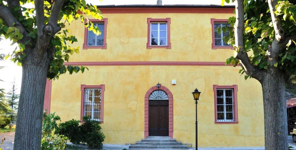 ein gelbes Haus mit Tür und Treppe vorne in der Unterkunft Villa Eugenia in Cairo Montenotte