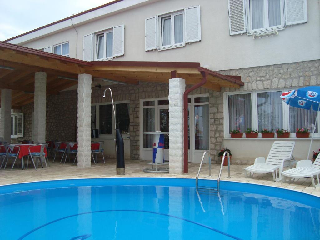 a swimming pool in front of a house at Vila Punta in Šibuljina