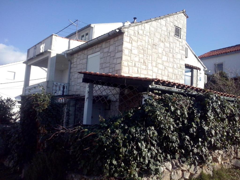 ein Haus mit einer mit Efeu bedeckten Wand davor in der Unterkunft Apartment Ma're in Supetar
