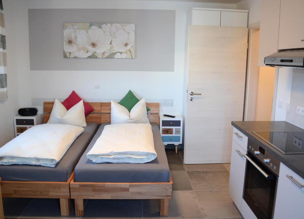 a small room with two beds in a kitchen at Gästehaus Brunnerhof - Reisen in Eitting