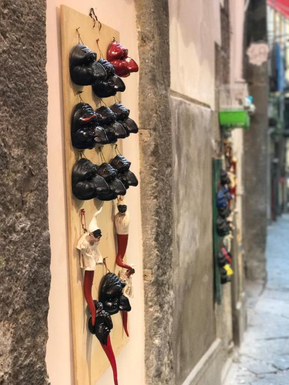 un grupo de zapatos colgando de una pared en Smart Central Apartments San Gregorio, en Nápoles