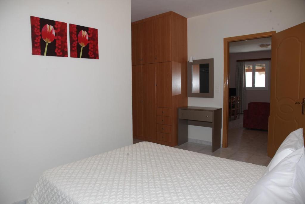 a bedroom with a white bed and a desk at Villa Elena in Lixouri