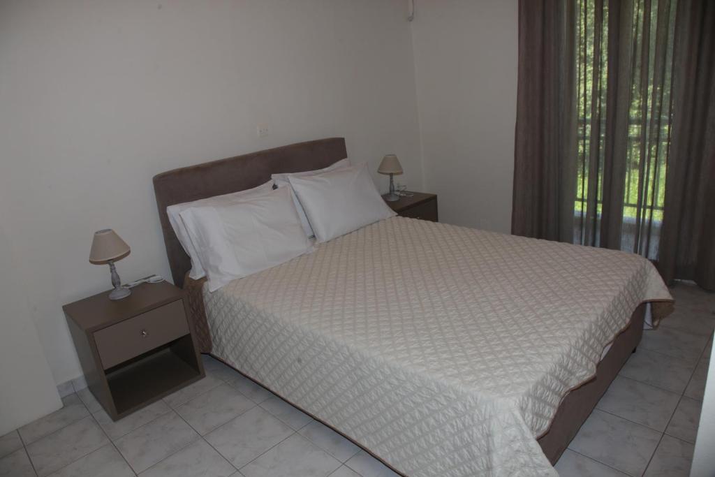 a bedroom with a large bed with two night stands at Villa Elena in Lixouri